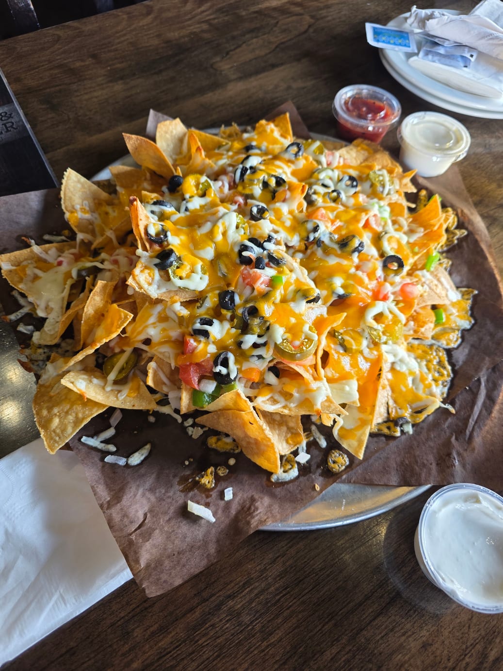 Palermo Nachos piled with cheese, peppers, tomatoes, jalapeños and black olives