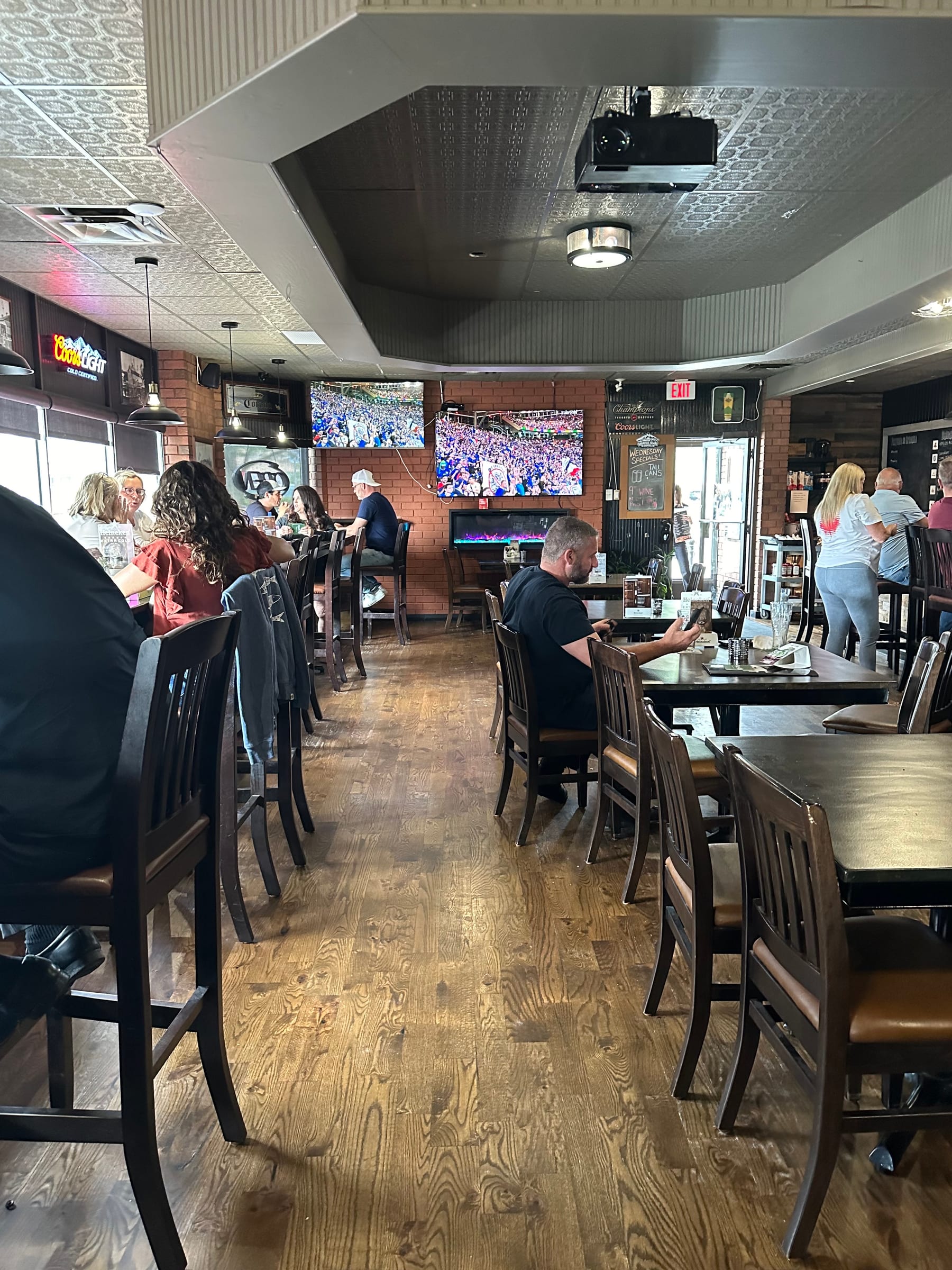 The Palermo Pub dining room: wood floor, booths and tables, and the TVs along the back wall
